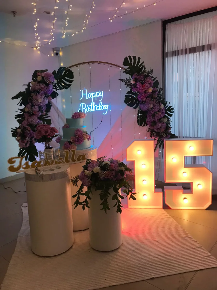 Decoración temática con arco floral y letras iluminadas