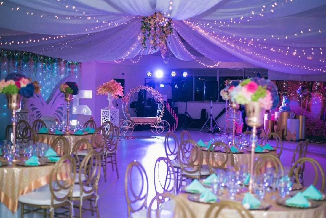 Salón temático con carroza iluminada y mesas para fiesta de 15