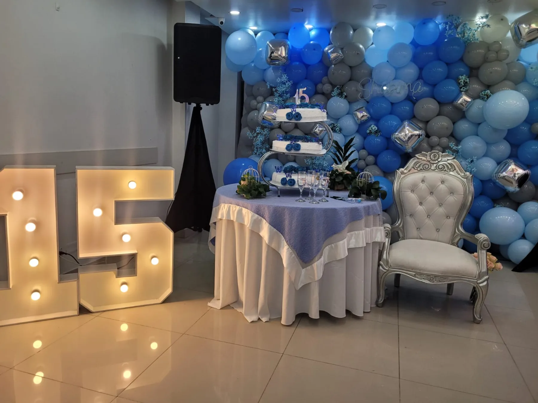 Mesa de torta con globos y números iluminados